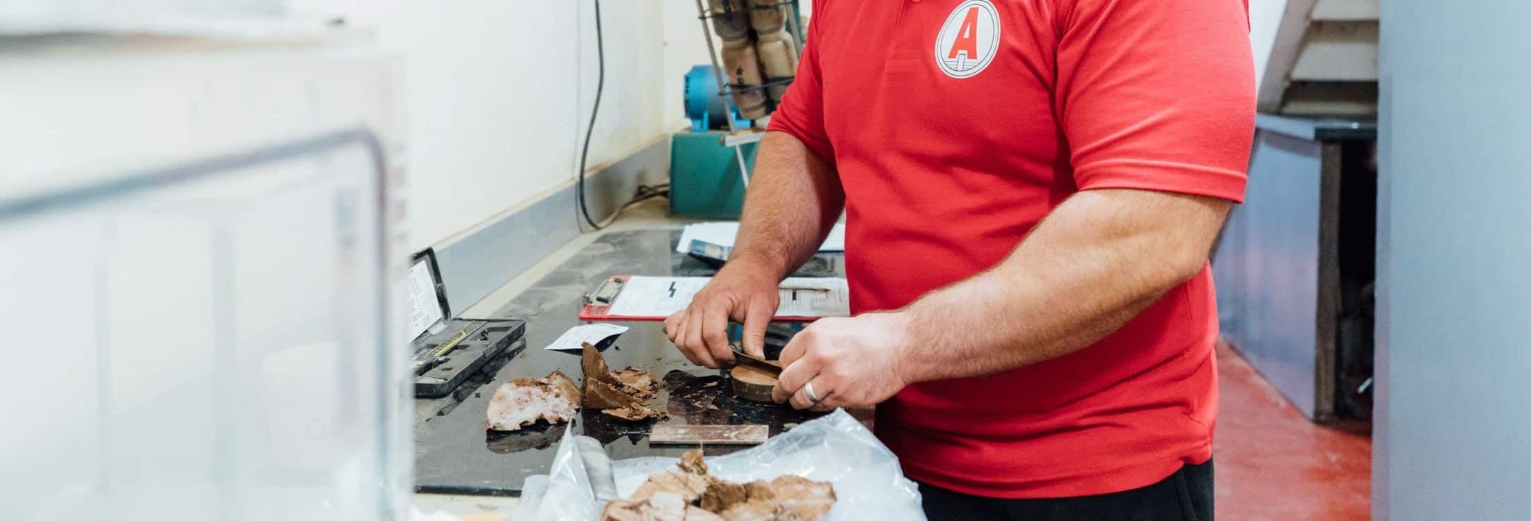 Aitken Labs technician analysing soil core samples for geotechnical testing.