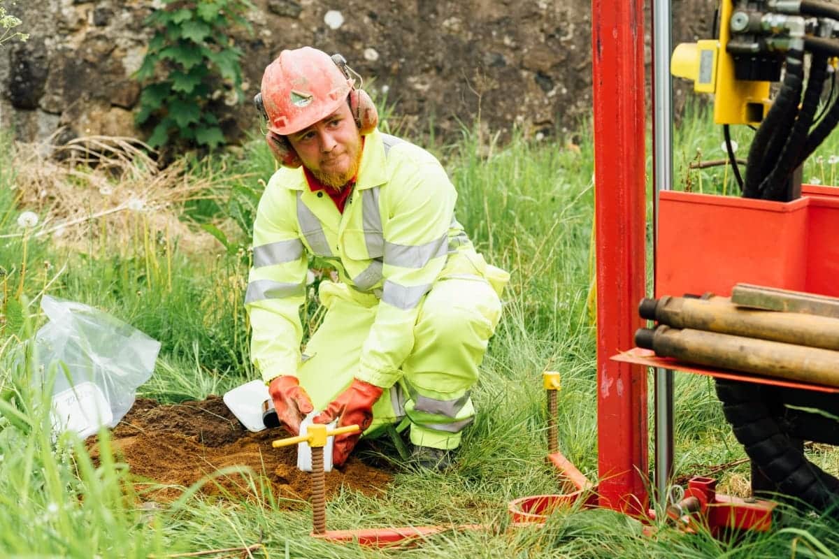 Aitken Labs engineer collecting soil samples for geotechnical site investigation