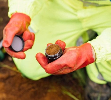 Engineer collecting a soil sample during a site investigation at a development plot